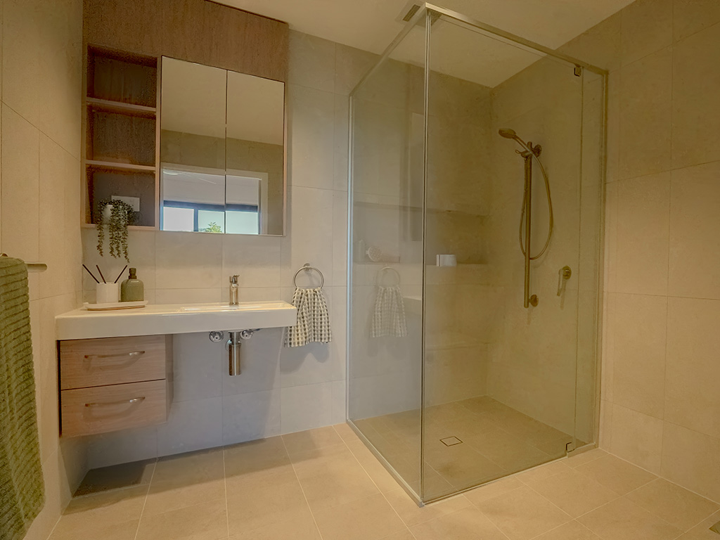 bathroom with sink vanity and shower on rail at Assisi apartments